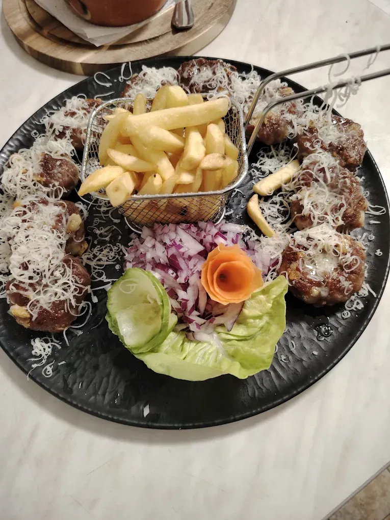 Roštilj sa rendanim sirom, pomfritom i crnim lukom